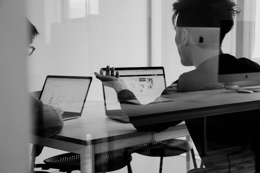 Person working at a modern desk with multiple monitors showing data